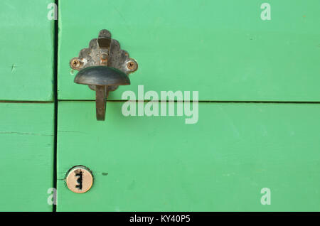 Poignée rustique antique et serrure sur une porte en bois vert Banque D'Images