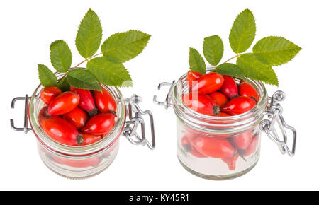 Deux pots avec des cynorrhodons rouges et feuilles vertes. Hanches frais mûrs et brier brindille dans un bocal en verre. Isolé sur fond blanc. Banque D'Images