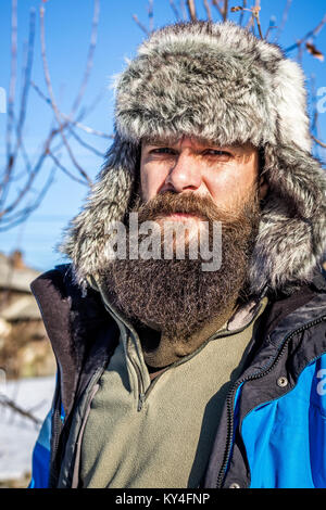 Closeup portrait d'un jeune homme barbu avec bonnet de fourrure outdoor Banque D'Images