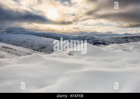 Les conditions d'hiver de neige et de verglas à marcher le long de la voie vers la montagne Meall Dubh (un Graham) (à l'arrière), Wester Ross, Scotland Banque D'Images