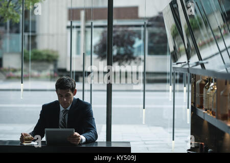 Businessman using digital tablet whisky tout en ayant Banque D'Images