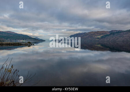 Les nuages et les montagnes se reflètent sur la surface du Loch Ness sur un jour, toujours à la recherche d'hivers Fort Augustus. Banque D'Images