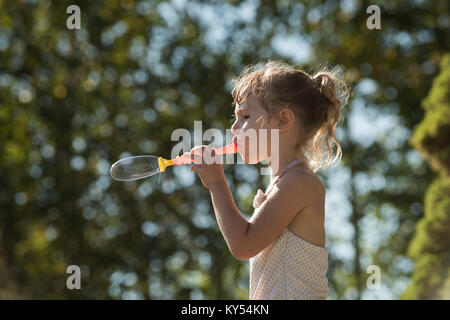 Cute girl Playing with bubble wand Banque D'Images