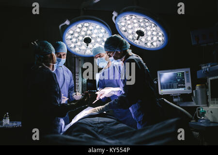 L'équipe médicale d'effectuer la chirurgie dans l'hôpital. Groupe de chirurgiens à travailler en salle d'opération. Banque D'Images