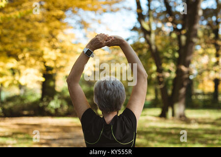 Vue arrière du senior woman practicing yoga in a park Banque D'Images