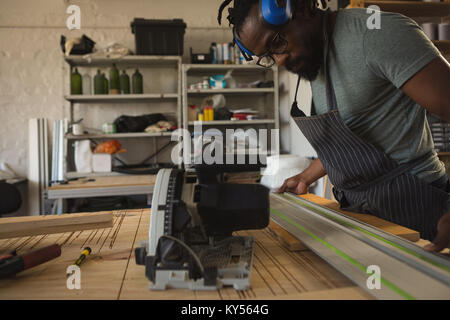 Carpenter measuring planche en bois avec ruban de mesure Banque D'Images