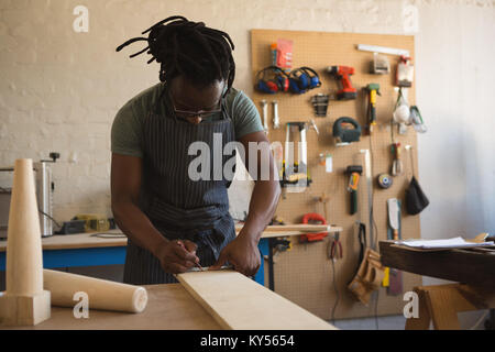 Carpenter measuring planche en bois Banque D'Images