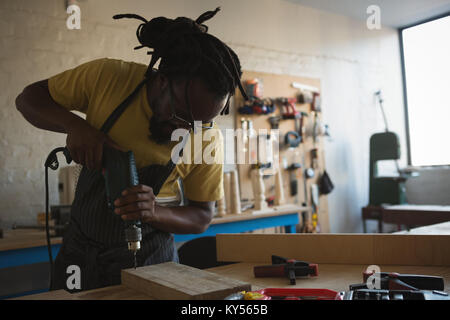 Carpenter drilling planche en bois avec la machine Banque D'Images