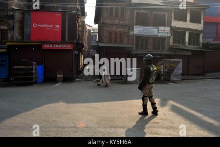 Srinagar, au Cachemire. 13 Jan, 2018. Les femmes musulmanes cachemire devant Kashmirn policier qui monte la garde pendant un couvre-feu dans la région de Srinagar, Cachemire administré par Kashmirn. Les autorités ont imposé des restrictions de Srinagar, en plus de parties de civil lines le samedi à la suite de grève déclenchée par les séparatistes à l'encontre de civils dans la vallée. Credit : Saqib Majeed/SOPA/ZUMA/Alamy Fil Live News Banque D'Images