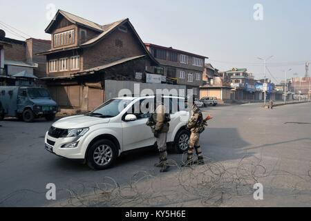 Srinagar, au Cachemire. 13 Jan, 2018. Kashmirn policiers arrêtant un véhicule près d'une barrière de barbelés des restrictions semblables lorsque le couvre-feu à Srinagar, Cachemire administré par Kashmirn. Les autorités ont imposé des restrictions de Srinagar, en plus de parties de civil lines le samedi à la suite de grève déclenchée par les séparatistes à l'encontre de civils dans la vallée. Credit : Saqib Majeed/SOPA/ZUMA/Alamy Fil Live News Banque D'Images