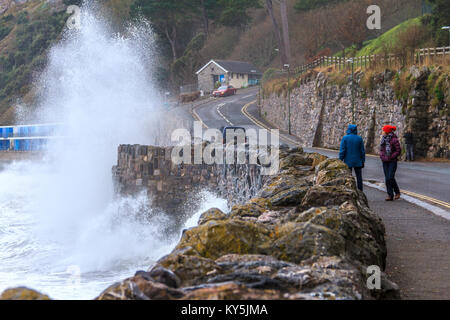 Les passants regardent la mer vagues violation mur à la plage de Meadfoot à Torquay, Torbay, dans le Devon, Royaume-Uni. Janvier 2018. Banque D'Images