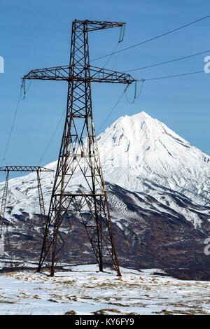 Ligne à haute tension sur une journée ensoleillée. Vue sur les tours de métal haute tension en arrière-plan sur la montagne enneigée de cône de Volcan Vilyuchinsky. Ka Banque D'Images