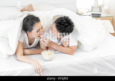 Les jeunes couples asiatiques de prendre le petit déjeuner sur le même lit dans la chambre de maison contemporaine de style moderne concept Banque D'Images