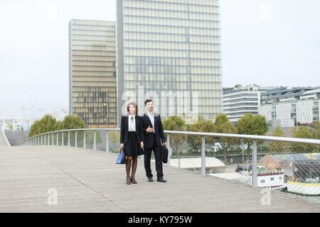 Les économistes à pied pendant la pause déjeuner, marié American middle-aged couple avoir un en-cas. Man and Woman smiling communication portant des costumes stricts. Banque D'Images