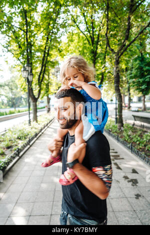 Petite fille à cheval sur les papas cou Banque D'Images