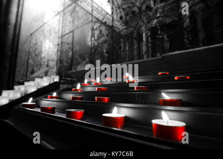 Bougies votives lumignons église rouge couleur noir et blanc sélectif Banque D'Images