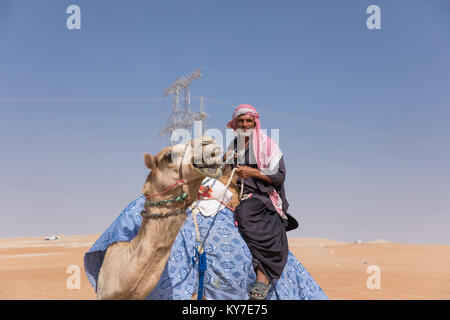 Abu Dhabi, UAE - Dec 15, 2017 : old man riding son chameau dans le désert au cours d'Al Dhafra camel festival. Banque D'Images