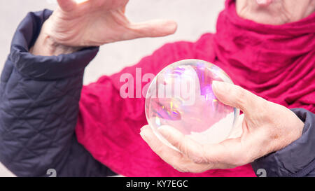 Plus gros plan de la main de femme tenant une sphère de verre brillant Banque D'Images