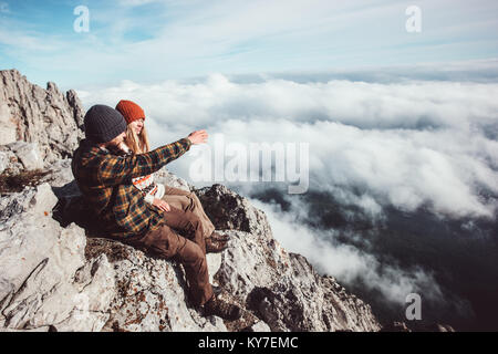 Couple Homme et femme assis sur des rochers en montagnes et nuages amour paysage avec une assurance vie émotions concept. Jeune famille voyageant Banque D'Images