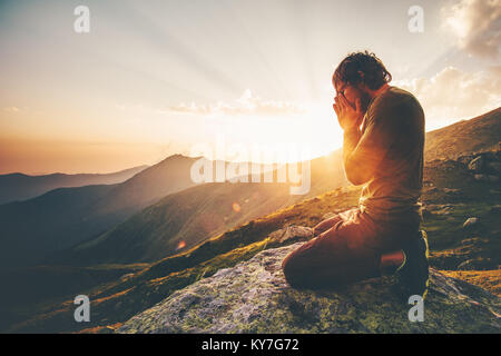 Homme qui prie au coucher du soleil spirituel de vie voyage montagne émotionnelle relaxation méditation vacances concept outdoor avec harmonie nature paysage Banque D'Images