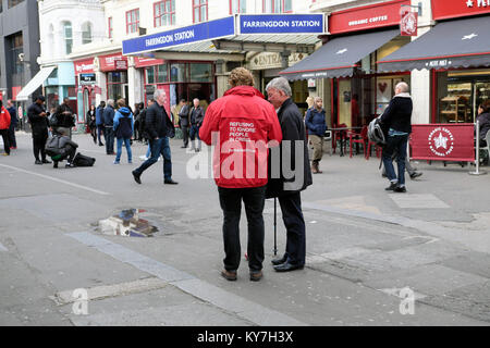 La charité de la Croix Rouge et l'homme travailleur talk pour collecter des dons dans la rue en face de la gare de Farringdon sign in London England UK KATHY DEWITT Banque D'Images