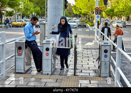 Isfahan, Iran - 23 Avril 2017 : une femme en vêtements islamique" passe à l'arrêt de bus par l'intermédiaire de tourniquet. Banque D'Images