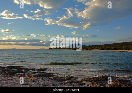 La mer Adriatique à l'île de Losinj sur l'horizon, avec une plage de maquis et de montagnes sur un jour nuageux Banque D'Images