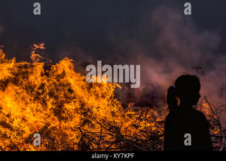 Jeune fille en face d'une fournaise de feu la nuit, Danemark, juin23, 2017 Banque D'Images