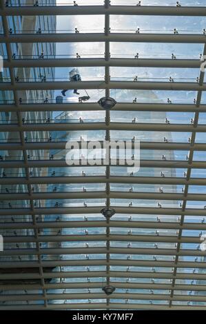 Un travailleur nettoie les vitres de toit d'un centre commercial dans la ville de Mexico. Banque D'Images
