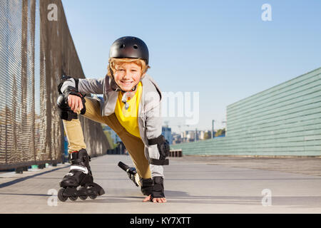 Close-up of preteen garçon blond avec des patins et matériel de protection à une rollerdrom Banque D'Images