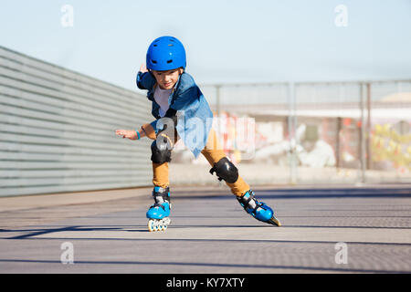 Portrait de preteen boy riding vite sur patins à roulettes au skate park en plein air en été Banque D'Images