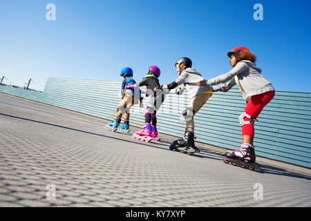 Heureux préadolescent de divertissement pour les jeunes alors que le patin à roues alignées l'une après l'autre sur la piste du stade de Banque D'Images