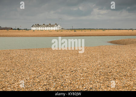 Une image de coastguard cottages tourné de l'autre côté de la plage de galets à Shingle Street, Suffolk, Angleterre, Royaume-Uni. Banque D'Images
