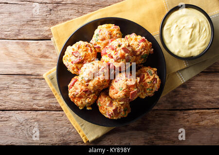 Des boules de saucisse avec cheddar fromage sur une assiette et la sauce à la moutarde dans un bol de près. haut horizontale Vue de dessus Banque D'Images