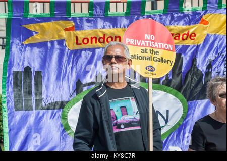 Un homme tient une pancarte "Non à la privatisation de la National Gallery' en face de la London Fire Brigade Unision banner à la fin du piquet le 61e jour de grève de la Galerie nationale. Banque D'Images