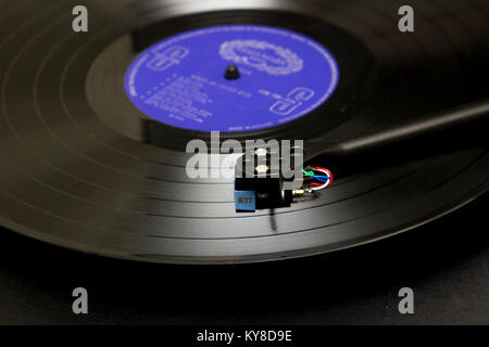 Une longue lecture d'un disque vinyle sur une platine avec bras et cartouche sur la vue. Le disque porte la vieille étiquette Marque Banque D'Images