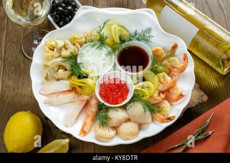 Ensemble de fruits de mer agrémenté de sauces sur plat blanc Banque D'Images