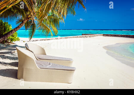 Des chaises longues en rotin sur Maldives beach, l'Océan Indien Banque D'Images