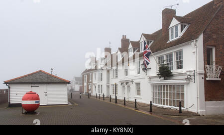 Burnham-on-Crouch, England, UK - 17 décembre 2016 : brume enveloppe partiellement les vieux bâtiments sur le port de Burnham sur l'estuaire de la rivière C Banque D'Images