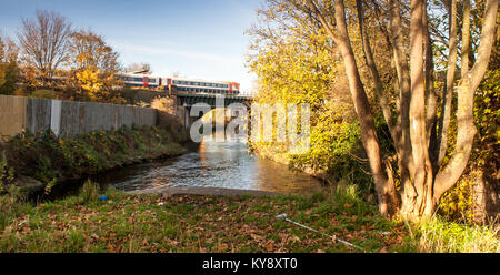 Londres, Angleterre, Royaume-Uni - 18 novembre 2012 : une classe de 444 Trains South West Trains de voyageurs traverse la rivière Wandle sur la ligne principale du sud-ouest en fer Banque D'Images