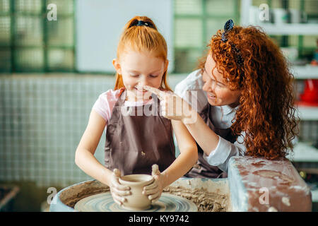 L'enseignant et l'élève faire pitcher de roue de poterie Banque D'Images