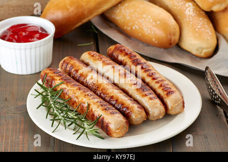 Saucisses grillées avec sauce et petits pains Banque D'Images