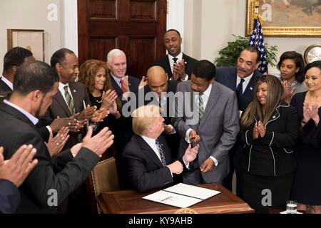 Le Président américain Donald Trump mains le stylo utilisé pour signer une proclamation en l'honneur du Dr Martin Luther King, un jour à l'Isaac Newton Farris, Jr., neveu de Martin Luther King Jr., au cours d'une cérémonie de signature dans la Roosevelt Room de la Maison Blanche le 12 janvier 2018 à Washington, DC. Banque D'Images