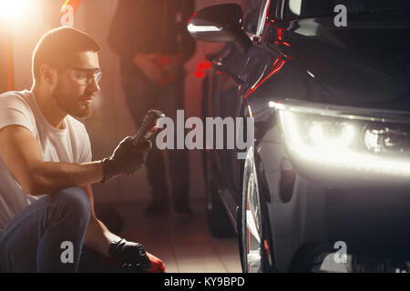 L'homme vérifie le polissage avec une torche Banque D'Images
