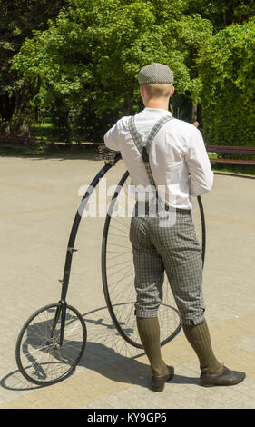Les jeunes cyclistes vêtus de vieux vêtements est debout avec son vélo appelé penny-farthing ou high wheel Banque D'Images