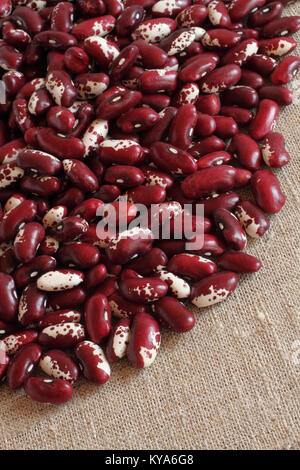 Tas de matières rouge avec des haricots rouges mouchetée blanc sur un tissu en lin Banque D'Images