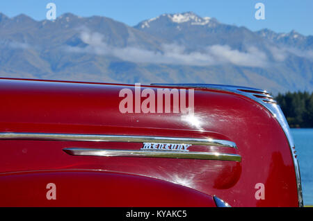 Mercury huit voiture vintage, avec le lac Wanaka et les montagnes au-delà. Région d'Otago en Nouvelle-Zélande Banque D'Images