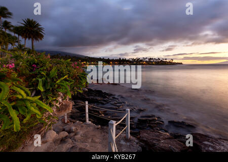 Chemin le long de la côte rocheuse à Napili Point au crépuscule à Maui, Hawaii. Banque D'Images