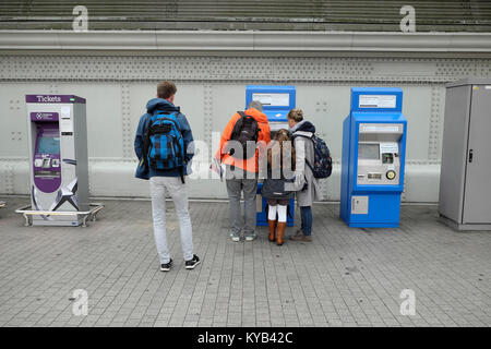 Un homme debout, attend une famille pour acheter des billets de train d'une nouvelle machine de billets à la gare de Paddington à Londres Angleterre Royaume-uni KATHY DEWITT Banque D'Images