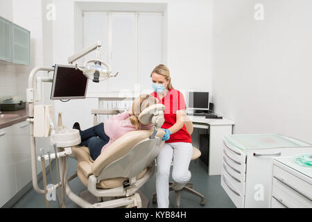 Femme avec la bouche ouverte après avoir examiné ses dents par un dentiste femelle. Dents checkup au bureau du dentiste. Bureau de dentiste Banque D'Images